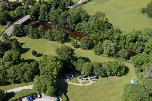 an overhead view of a park with trees and a house at The Plough Inn in Hathersage