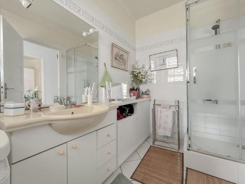 une salle de bain blanche avec un lavabo et une douche dans l'établissement Appartement 2 pièces en front de mer à Fréjus avec parking and vue mer, à Fréjus