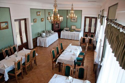 a dining room with tables and chairs and a chandelier at Hotel Zamek Pułtusk Dom Polonii in Pultusk