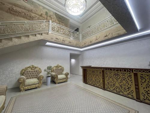 a large room with two chairs and a staircase at Anor Qal'a in Khiva
