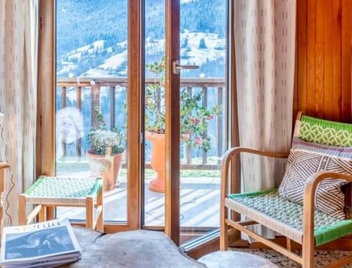 une chambre avec deux chaises et une fenêtre dans l'établissement Le Mazot du Genévrier - Au coeur des Aravis, à Les Clefs