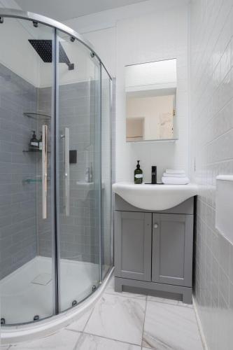 a bathroom with a sink and a glass shower at Excellent 4 Bedroom in Griffintown Downtown MTL in Montréal