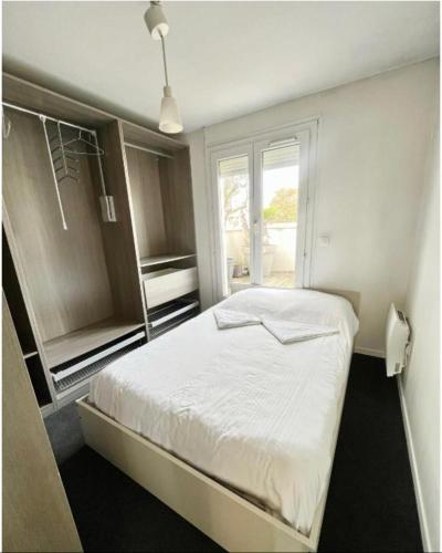 une chambre avec un lit blanc et une fenêtre dans l'établissement LAGRIVE - Appartement avec balcon, à Reims