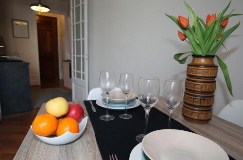 une table avec un bol de fruits et des verres à vin dans l'établissement Balcon sur le lac, à Annecy