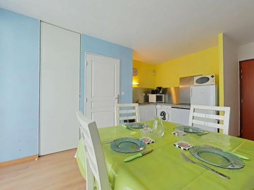 une salle à manger avec une table et des chaises vertes dans l'établissement Appartement moderne 2P, 4 couchages, terrasse, proche plage et centre, parking, St Gilles Croix de Vie - FR-1-224-217, à Saint-Gilles-Croix-de-Vie
