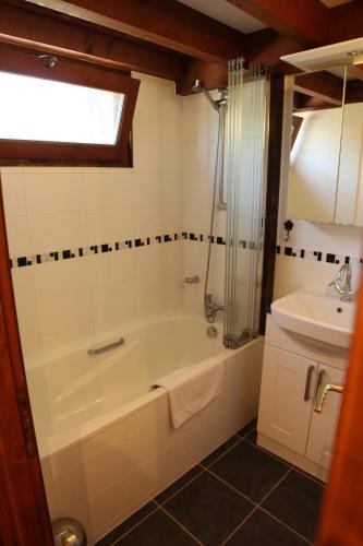 une salle de bain avec une baignoire et un lavabo dans l'établissement Apartment La Corniche, Central Morzine, sleeps 6, à Morzine