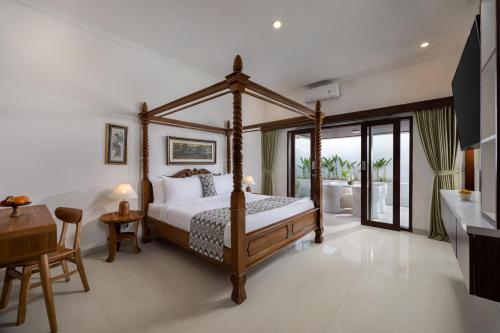 um quarto com uma cama de dossel e uma mesa em Romantic Cozy Three Bedroom Jungle View Villa in Ubud em Tegalalang