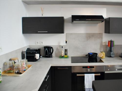 a kitchen with a sink and a stove top oven at Le coeur d'Angoulême, calme et spacieux in Angoulême