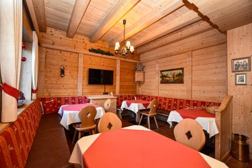 een restaurant met tafels en stoelen en een flatscreen-tv bij Appartements by Hotel-Garni Austria in Westendorf