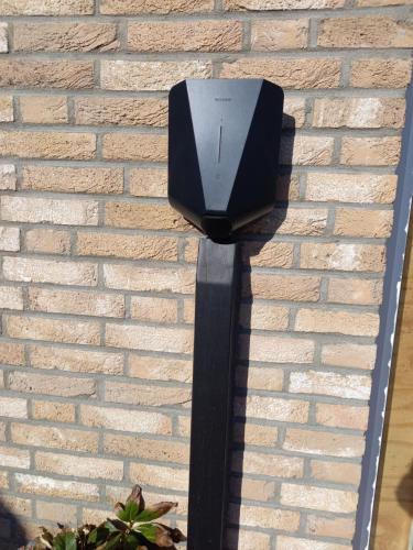 a black box on the side of a brick wall at Room by the sea in Zoutelande