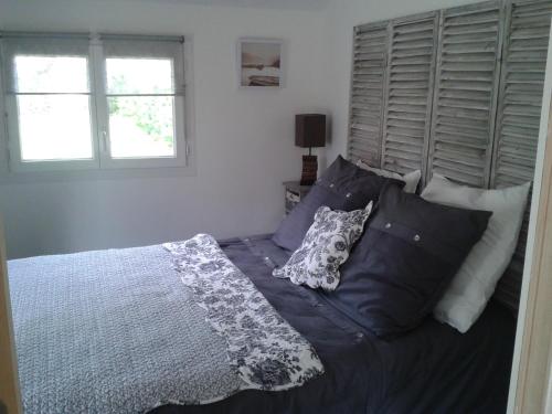 une chambre avec un lit avec des draps et des oreillers bleus dans l'établissement Gite de la Bastide de Mongiraud - à Proximité de Nombreux Sites Touristiques - Bassin D'Arcachon et Châteaux, à Blanquefort