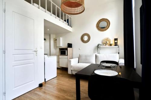 un salon avec une table et un canapé blanc dans l'établissement Lille Centre Studio, à Lille