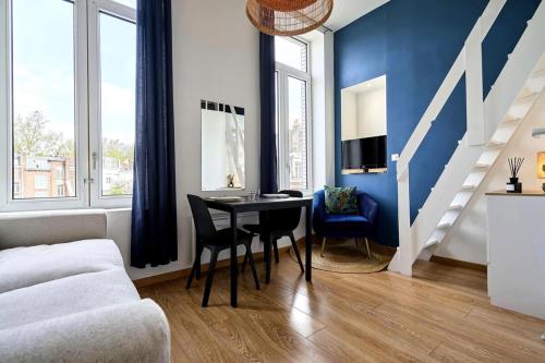 un salon avec une table et un mur bleu dans l'établissement Lille Centre Studio, à Lille