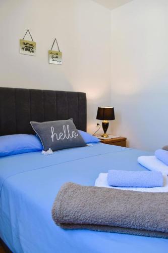 a blue bed with blue sheets and towels on it at Oguic apartman in Pag