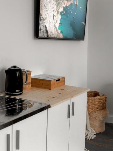 a kitchen with white cabinets and a wooden counter top at Boho Living at Cieszyn Studio in Cieszyn