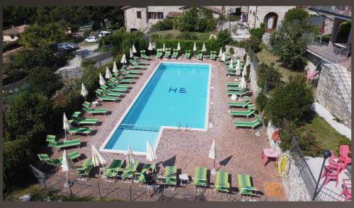 an overhead view of a swimming pool with chairs and umbrellas at Hotel MioMio in Tignale