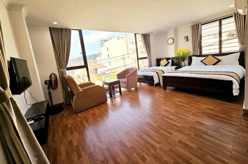 a hotel room with two beds and a large window at Khách Sạn Thụy Điển SaPa in Sa Pa