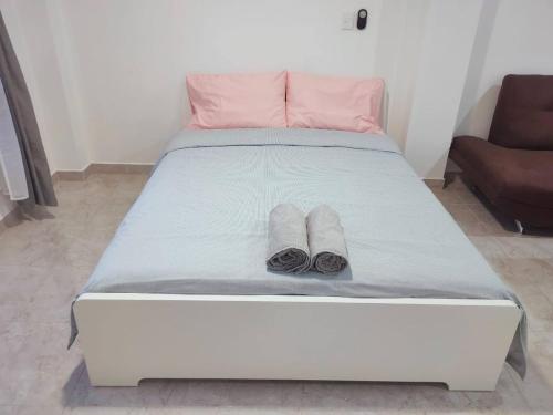 a white bed with two pairs of slippers on it at Studio del Centro in Huajuapan de León