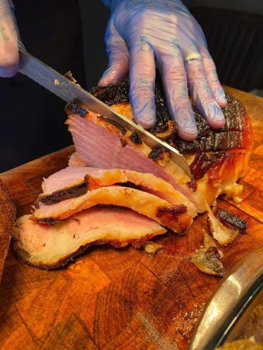 a person cutting a piece of meat with a knife at Y Castell in Caernarfon