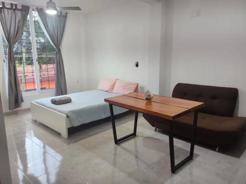 a bedroom with a bed and a table and a chair at Studio del Centro in Huajuapan de León