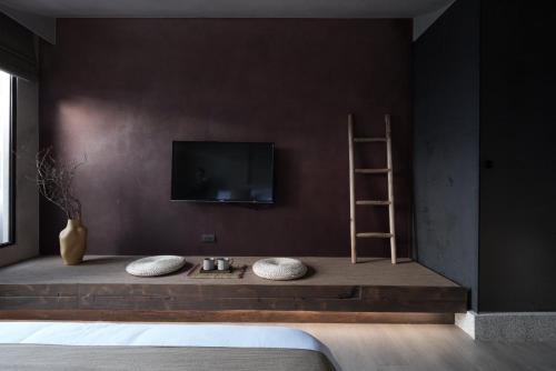 a bedroom with a tv on a wall with two pillows at Jiufen 35 in Jiufen