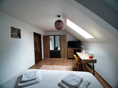 a bedroom with a bed and a desk with a lamp at Armonia Apartment Sibiu in Sibiu