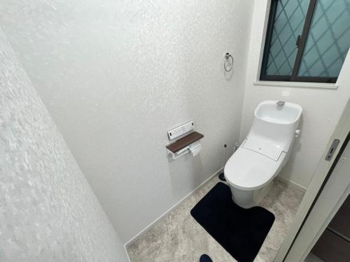 a bathroom with a white toilet and a window at FabulousOdawara in Odawara