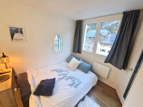 une petite chambre avec un lit et une fenêtre dans l'établissement Appartement Cosy, Vue MontBlanc, Chamonix Centre, à Chamonix-Mont-Blanc