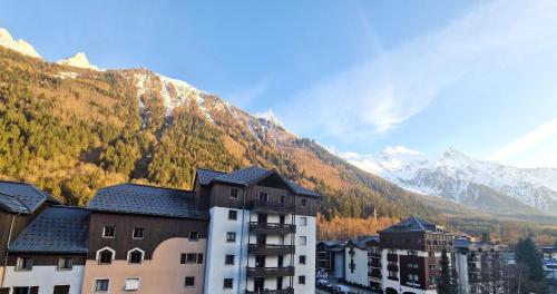 un bâtiment avec une montagne en arrière-plan dans l'établissement Appartement Cosy, Vue MontBlanc, Chamonix Centre, à Chamonix-Mont-Blanc