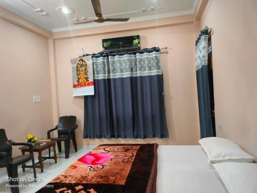 a bedroom with a bed and a curtain and a table at Saraswati homestay in Ayodhya