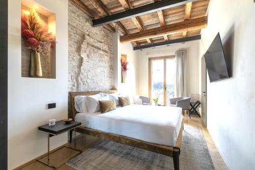 a bedroom with a large white bed and a television at Palazzo CarpeDiem-Prato della Valle in Padova