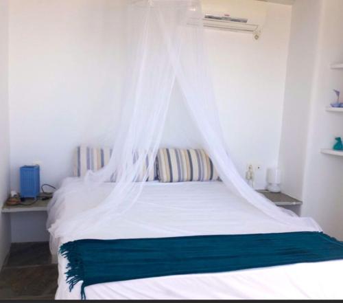 a bedroom with a white bed with a mosquito net at Maridina House in Livadi