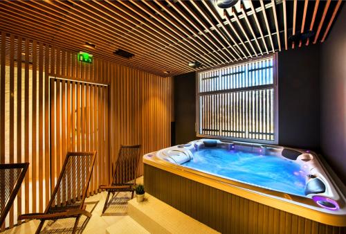 a hot tub in a room with two chairs at TERNELIA Le Vent Du Large in Saint-Gilles-Croix-de-Vie