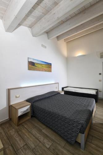 a bedroom with a bed and a wooden floor at Cantina Langelina in Corinaldo