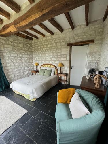 une chambre avec un lit et un canapé dans une pièce dans l'établissement Tourelle haute, à Panzoult