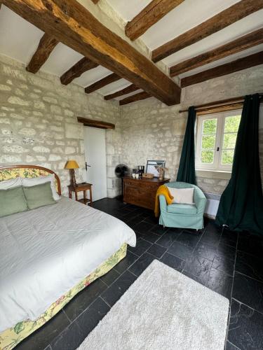 une chambre avec un lit, une chaise et une fenêtre dans l'établissement Tourelle haute, à Panzoult