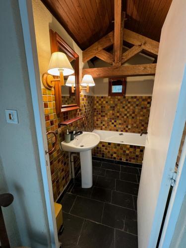 une salle de bain avec un lavabo et une baignoire dans l'établissement Tourelle haute, à Panzoult