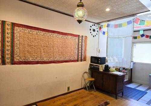 a room with a curtain on a wall with a desk at Santana Guest House Osaka in Osaka