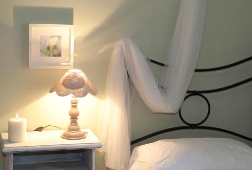 a bedroom with a bed with a lamp and a candle at Borgo al Cielo - Albergo Diffuso in Suvereto