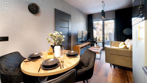a living room with a table and some chairs at Apartamenty Good Time - Belle View - Centrum in Szklarska Poręba