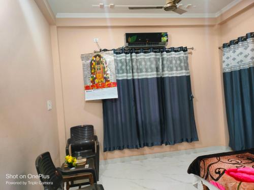 FaizābādにあるGaurav Orchid Homestayのベッドとカーテン付きの部屋