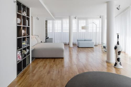 a living room with a bed and a couch at The Mandala Berlin, a Member of Design Hotels in Berlin