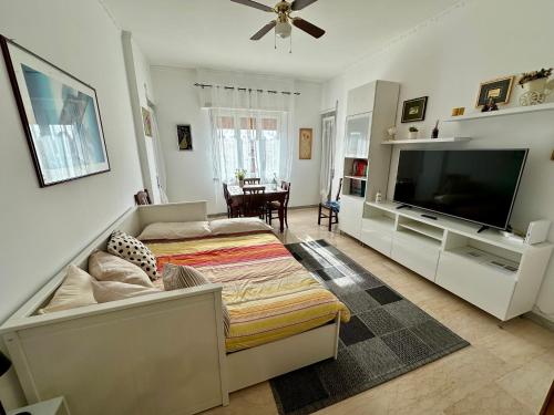 a living room with a flat screen tv and a bed at Madi house Ciampino in Ciampino
