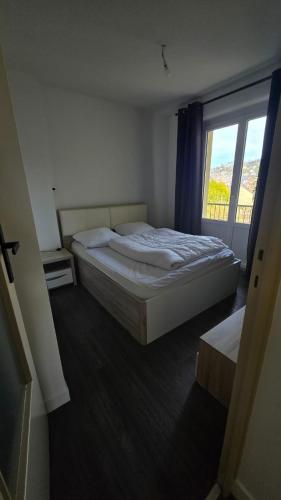 une chambre avec un lit et une grande fenêtre dans l'établissement Le Bonaparte, à Aix-les-Bains