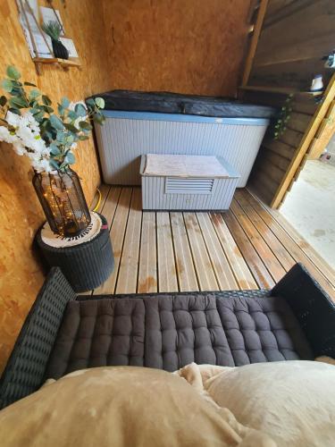 a bed sitting on a wooden floor with a bath tub at Le milazo au cœur de la campagne in Touffreville