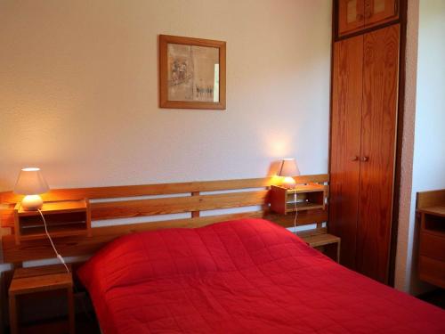 - une chambre avec un lit rouge et deux lampes dans l'établissement Appartement 6 personnes au centre des Orres 1650 avec accès direct aux pistes - FR-1-322-546, aux Orres