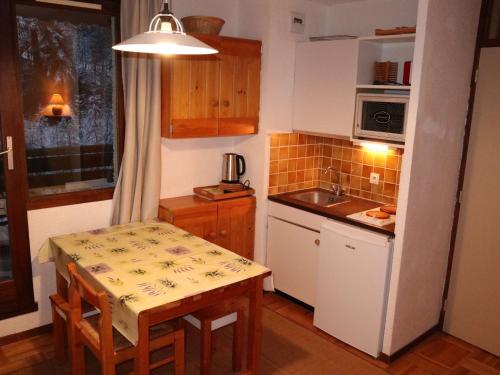 une petite cuisine avec une table et un évier dans l'établissement Studio 4 pers, centre Les Orres 1650, proche pistes - FR-1-322-576, aux Orres