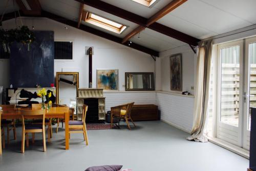 a dining room with a table and a fireplace at Atelier La Luna in Berkenwoude