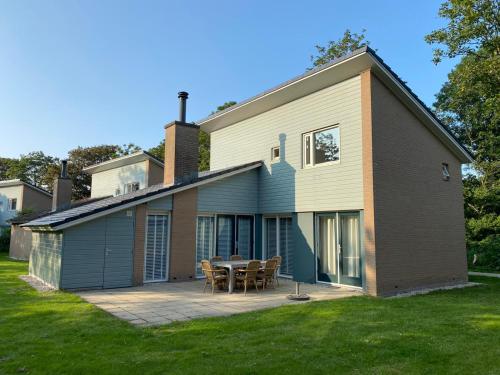 a house with a table and chairs on a patio at Vakantiewoning Kijkduinpark in The Hague