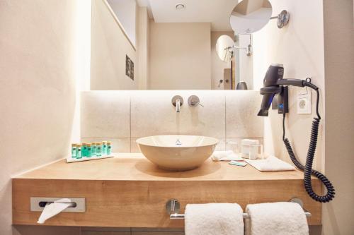 ein Bad mit einem Waschbecken und einer Dusche in der Unterkunft Seehotel Maria Laach in Maria Laach